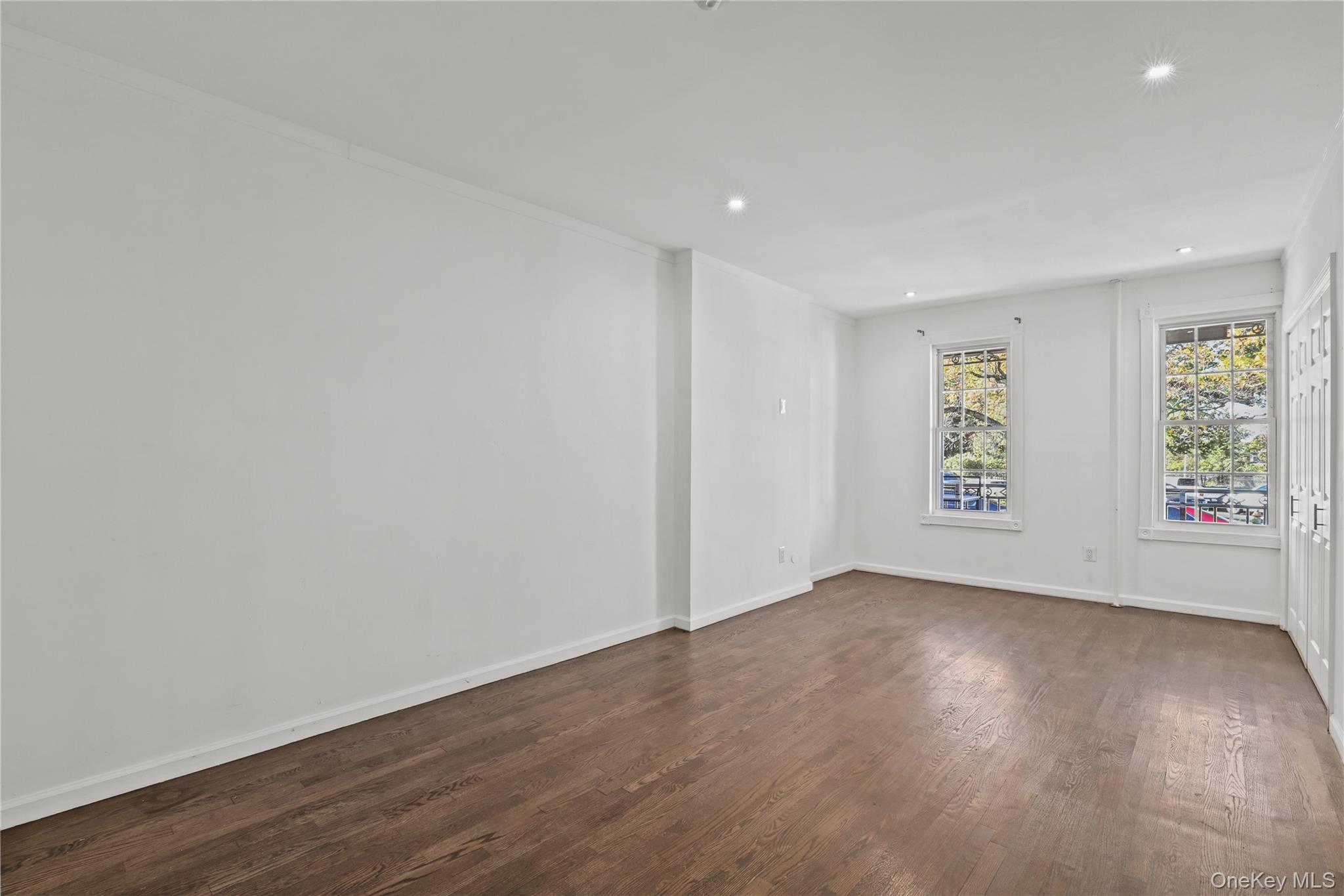 1448 Edwards Avenue Bronx, NY 10461 - Photo 4 of 28 an empty room with wooden floor and windows