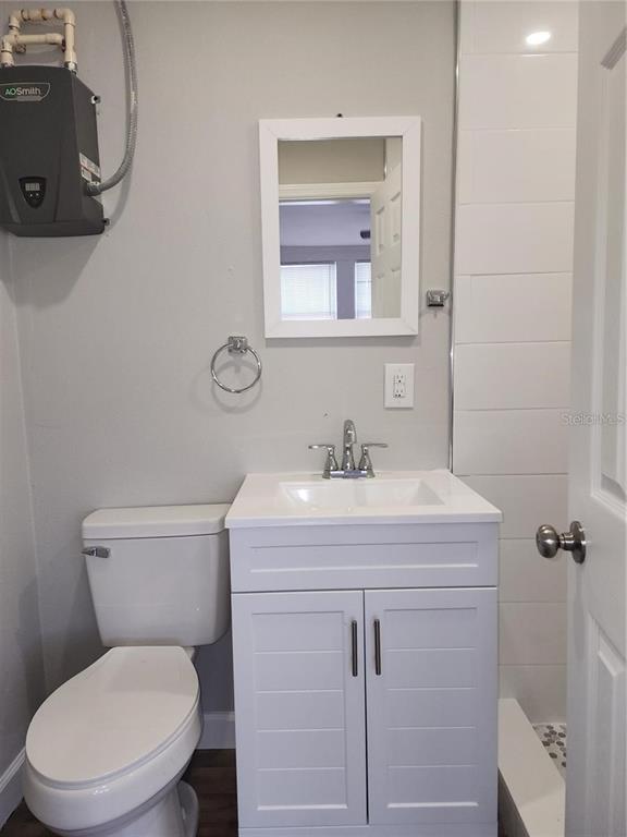 1339 7th Street Southwest Winter Haven, FL 33880 - Photo 9 of 11 a bathroom with a granite countertop toilet sink and mirror