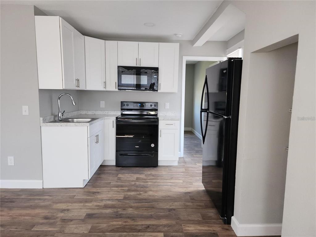 1339 7th Street Southwest Winter Haven, FL 33880 - Photo 10 of 11 a kitchen with stainless steel appliances granite countertop a refrigerator stove and sink