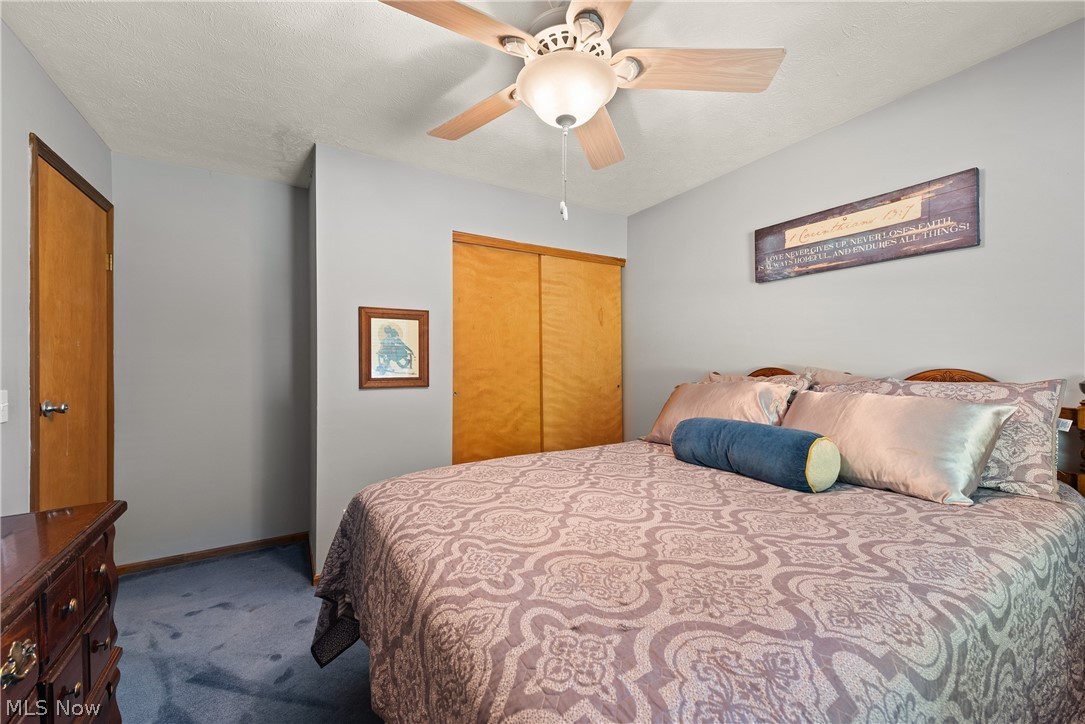 75 Houghton Road Northfield, OH 44067 - Photo 23 of 48 Textured ceiling with a ceiling fan light fixture, wood-finish bi-fold closet doors, and wood-finish door with brushed nickel hardware