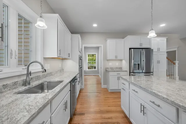 a kitchen with stainless steel appliances granite countertop a sink stove and refrigerator