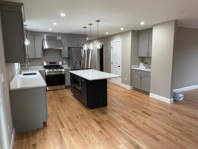 a kitchen with stainless steel appliances granite countertop a sink stove and refrigerator