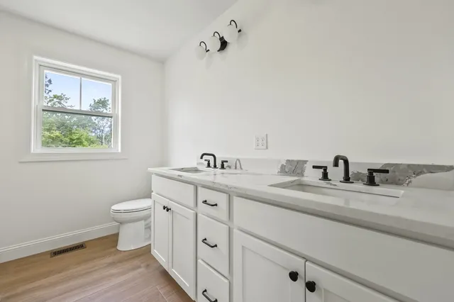 a bathroom with a toilet sink and mirror