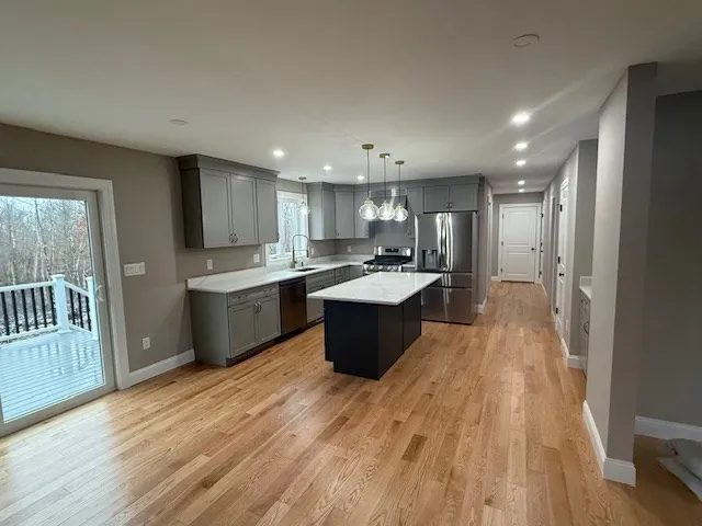 a large kitchen with stainless steel appliances lots of counter top space and a sink