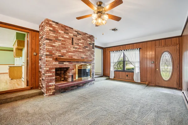 a view of an empty room with a fireplace and a large window