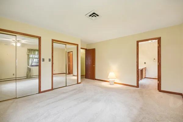 an empty room with windows and closet