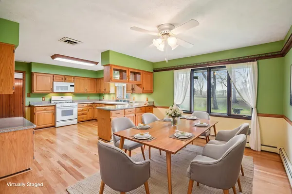 a dining room with furniture a large window and wooden floor