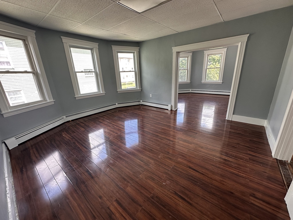 32 Ames Street Worcester, MA 01604 - Photo 4 of 21 an empty room with wooden floor and windows
