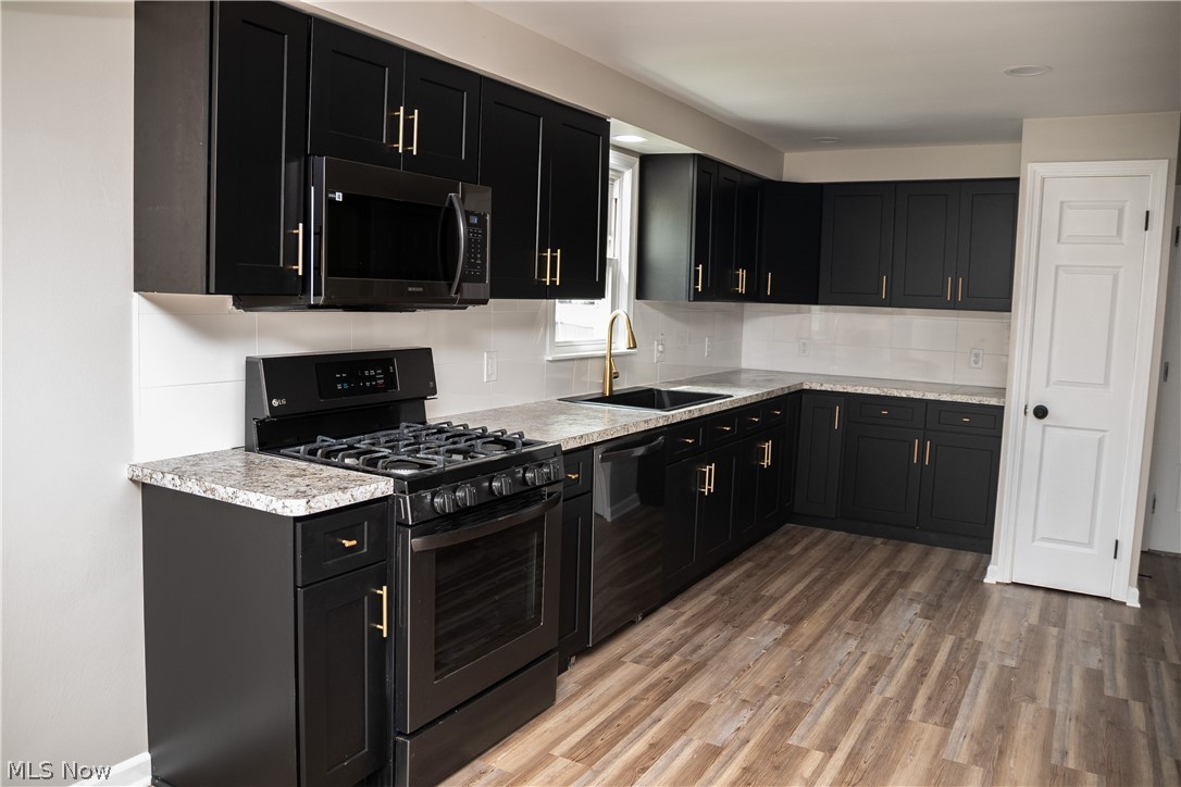 6666 Clingan Road Youngstown, OH 44514 - Photo 14 of 41 Kitchen with view of pantry, new cabinets, backsplash, black stainless appliances and new countertops
