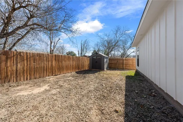 a view of a yard with wooden fence