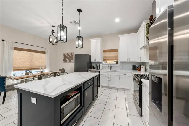 a kitchen with a sink stainless steel appliances cabinets and a counter top space