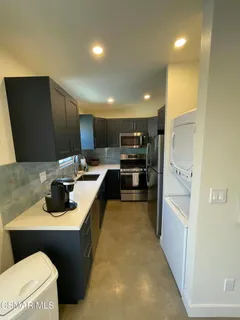 a kitchen with a refrigerator and a stove top oven