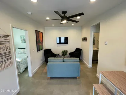 a living room with furniture and a ceiling fan