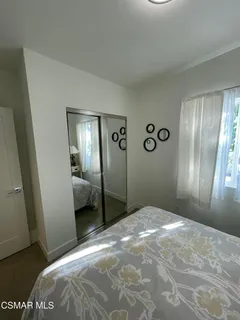 a bedroom with a bed and a lamp on dresser