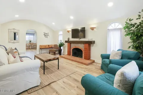 a living room with furniture a fireplace and a potted plant