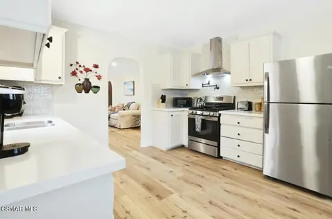 a kitchen with white cabinets and white appliances