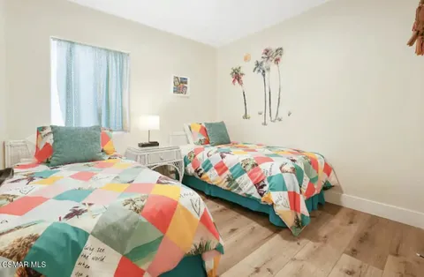 a bedroom with two beds and painting on the wall