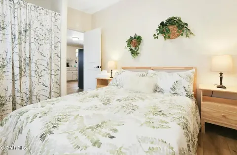 a bedroom with a bed and a wooden floor