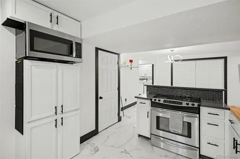 a kitchen with stainless steel appliances a stove a microwave and a refrigerator
