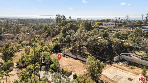 an aerial view of a house with a yard and mountain view in back
