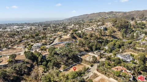 an aerial view of house with yard and mountain view in back
