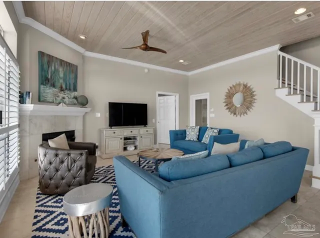 a living room with furniture a flat screen tv and a fireplace