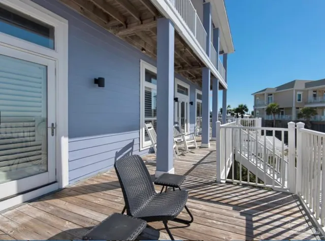 a view of a roof deck with table and chairs with wooden floor and fence