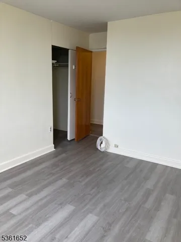 an empty room with wooden floor and closet
