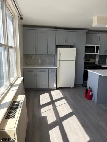 a kitchen with a refrigerator and a stove top oven