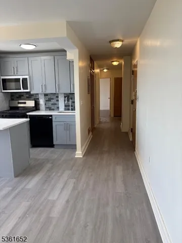 a view of a kitchen with a sink wooden floor and cabinets