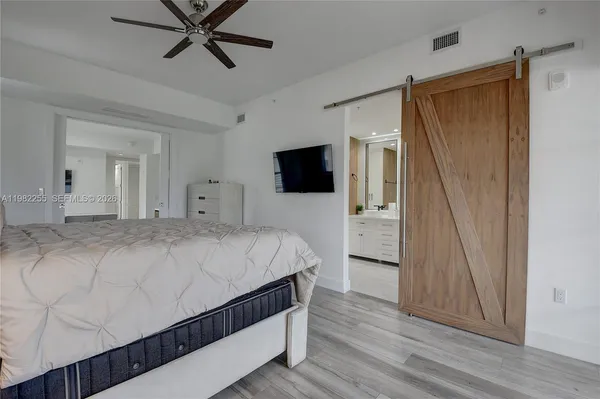 a bedroom with a bed and a flat tv screen on dresser