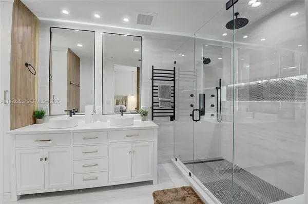 a bathroom with a double vanity sink mirror and shower