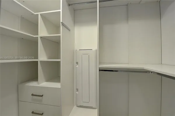 a view of walk in closet with empty racks