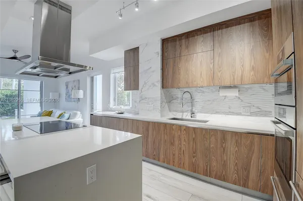 a kitchen with stainless steel appliances a sink dishwasher and cabinets with wooden floor