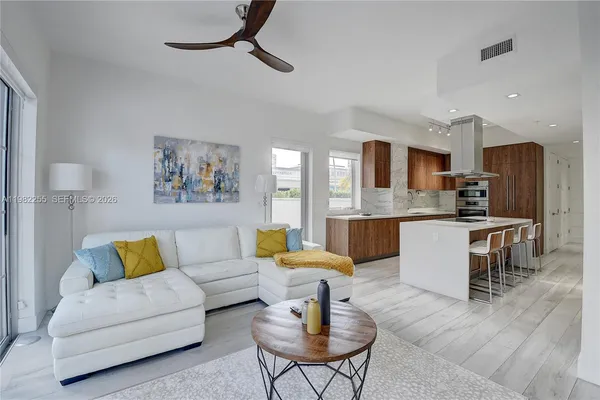 a living room with kitchen island furniture and a view of kitchen