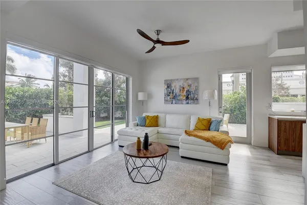 a living room with furniture a floor to ceiling window and a flat screen tv