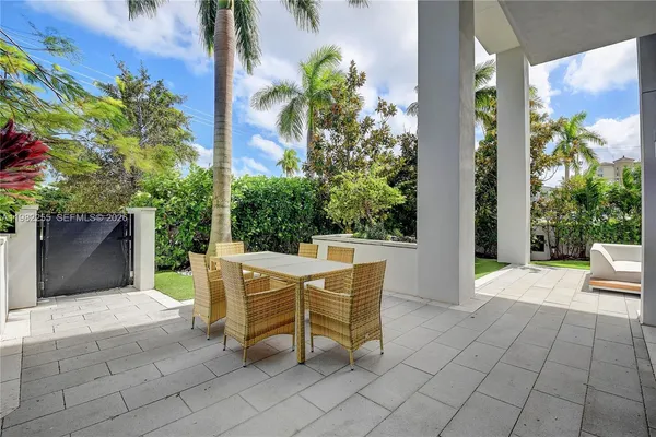 a view of a patio with a table and chairs and potted plants