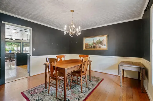 a dining room with furniture a chandelier and wooden floor