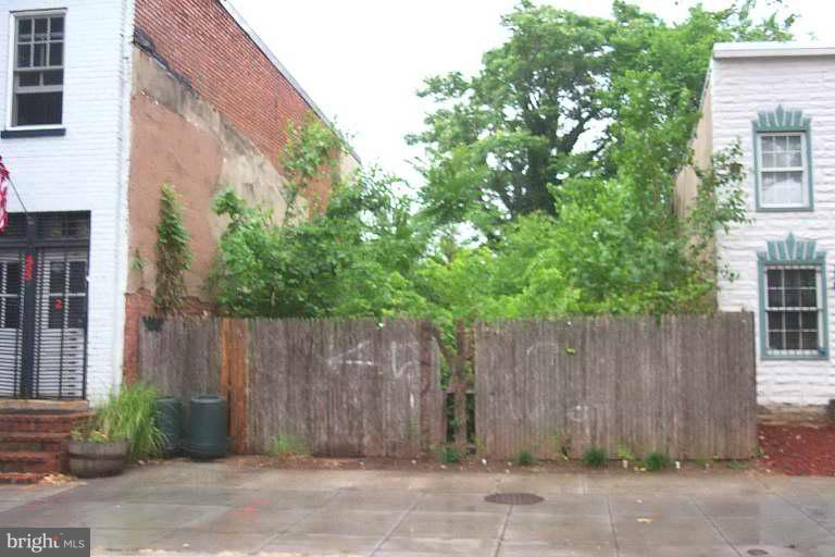 451 Ridge Street Northwest Washington, DC 20001 - Photo 1 of 1 a wooden fence and trees in front of a house