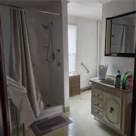a bathroom with a granite countertop sink a mirror and shower