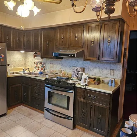 a kitchen with stainless steel appliances granite countertop wooden cabinets sink and stove