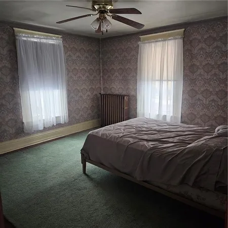 a bedroom with a bed and a ceiling fan