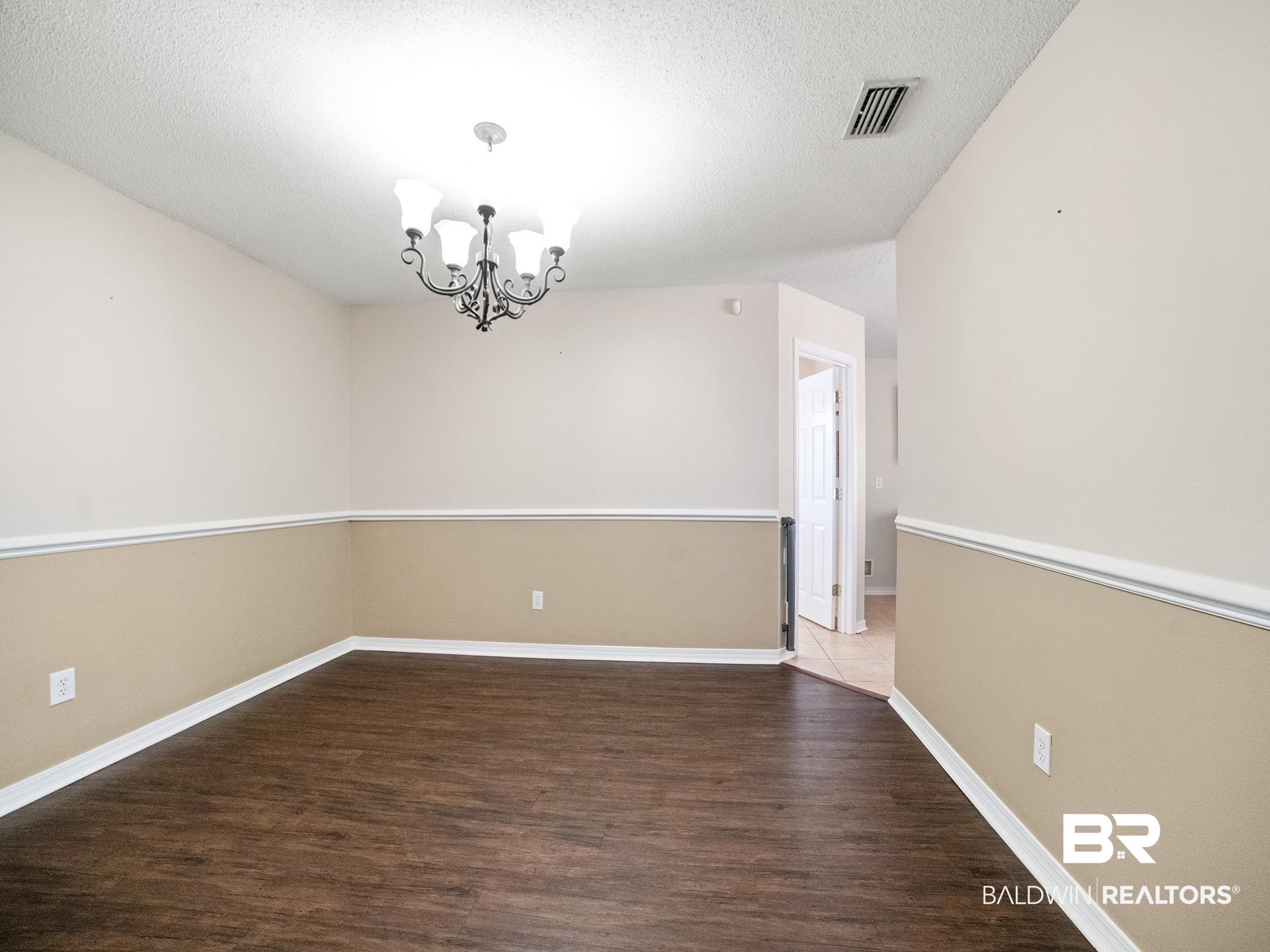 8320 Milton Road Mobile, AL 36695 - Photo 14 of 27 Unfurnished room featuring hardwood / wood-style floors, a chandelier, and a textured ceiling