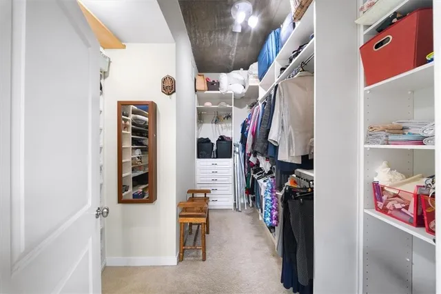 a view of walk in closet with clothes and shoes