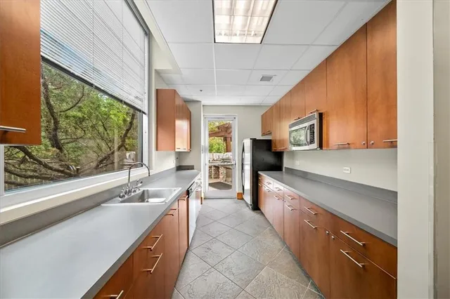 a large kitchen with stainless steel appliances granite countertop a lot of counter space and a sink