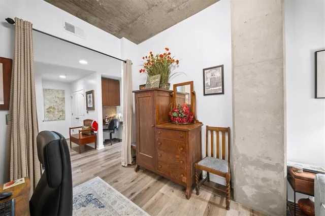 a living room with furniture and a dining table with wooden floor
