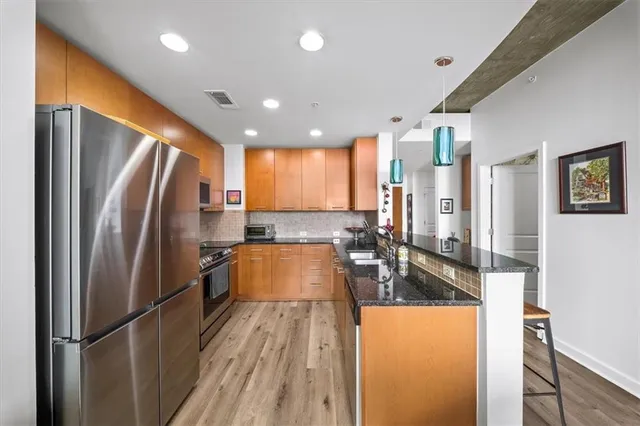 a kitchen with stainless steel appliances granite countertop a refrigerator and a sink