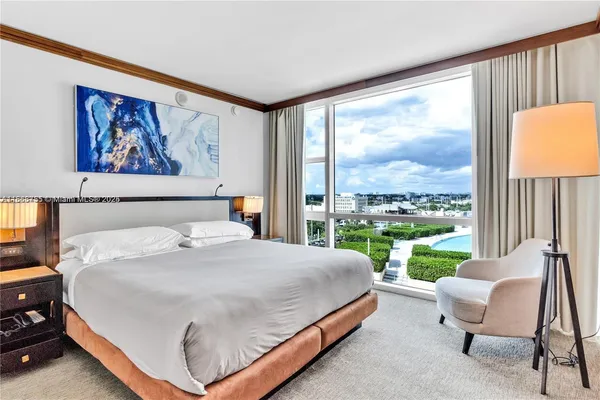 a bedroom with a bed and a large window