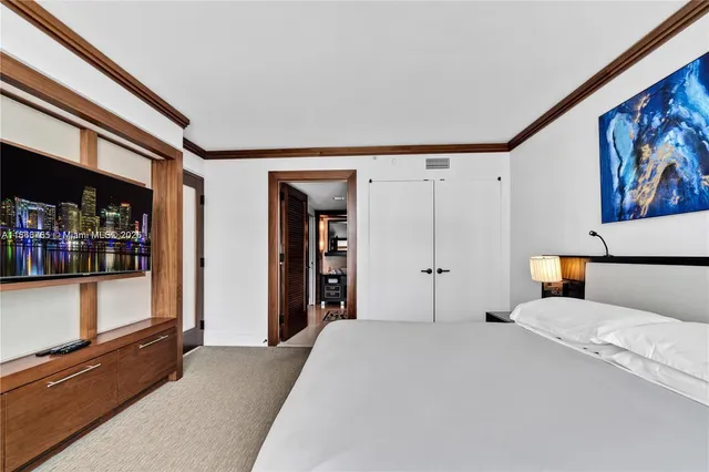 a bed room with a bed and a painting on the wall