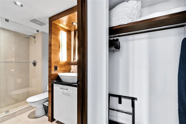 a bathroom with a granite countertop bathtub shower sink vanity and toilet
